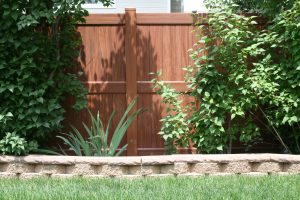 Mocha Walnut wood look vinyl fence with brick mow strip