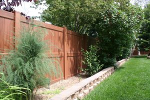 Mocha Walnut fence with mow strip and bushes