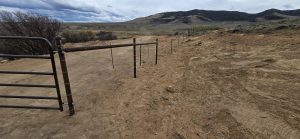 Barbed wire fencing on dirt road